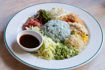 Wall Mural - Spicy rice salad with vegetable. Thai southern spicy rice vegetable with dressing on white plate, Thai local food.