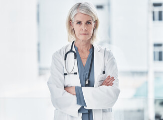 Poster - Mature, woman and doctor confident in portrait for career in medicine, healthcare and professional as general practitioner. Female medical worker, serious and arms crossed with pride in hospital.