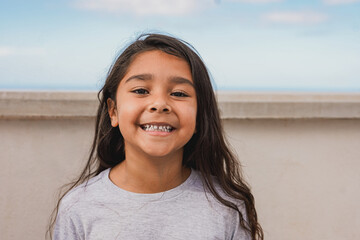 happy latin female child smiling on camera outdoor - childhood and carefree concept