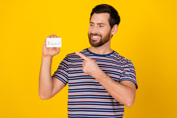 Poster - Photo of positive nice man with beard dressed striped t-shirt indicating look at credit card isolated on vibrant yellow color background