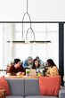 © Santi Nuñez/Stocksy - Diverse group discussing project in cozy workplace