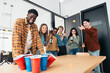 © Santi Nuñez/Stocksy - Office fun with a friendly game of beer pong