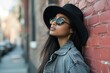 © juliars - Fashionable young woman with sunglasses and black hat posing on a city street