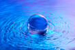 © Yaroslav Danylchenko/Stocksy - Crystal ball in water with blue and pink gradient effect on surface