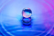 © Yaroslav Danylchenko/Stocksy - Crystal ball making splashes on water with blue and pink color