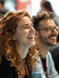 © Johannes - Close up picture of a happy and laughing staff or participant people group listening to a startup business owner at a trade show exhibition event. Generative AI.