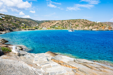 Wall Mural - Steps to beach and view of azure sea bay near Chrysopigi monastery, Sifnos island, Greece