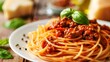 © rob3rt82 - A plate of spaghetti Bolognese with meat sauce and fresh basil leaves.