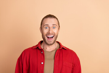 Wall Mural - Photo of nice young man open mouth wear red shirt isolated on beige color background