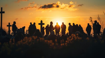 A group of people are gathered around a cross in a cemetery at sunset