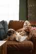 © Jordana Sheara/Stocksy - Beautiful woman with multicolored hair at home on couch with her dog