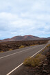 © Jonathan - A road with a mountain in the background. The road is empty and the sky is cloudy