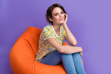 Poster - Photo of pretty young woman sit comfy bag wear t-shirt isolated on violet color background