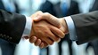 © BrightWhite - Strong handshake between business partners in suits symbolizing trust & collaboration; corporate setting with blurred colleagues in background.