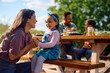 © Drazen - Happy girl talking to her mother during family picnic in nature.