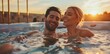 © PhotoPhantom - Young couple enjoying a romantic moment in a hot tub during sunset, smiling and relaxing together
