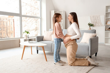 Canvas Print - Young pregnant woman with her little daughter at home