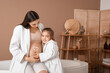 © Pixel-Shot - Little girl and her pregnant mother with heart made of cream on belly in bathroom