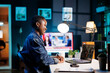 © DC Studio - Smiling female freelancer having video conference on digital laptop at her apartment. African American woman engrossed in her personal computer, attending online meeting with fellow colleagues.