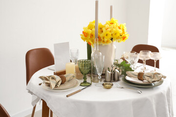 Wall Mural - Beautiful table setting with daffodils and candles for wedding celebration in room