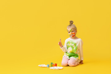 Sticker - Cute little girl in paint sitting on yellow background