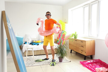 Sticker - Happy male tourist with snorkeling mask and swim ring in bedroom on vacation