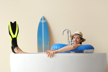 Poster - Male tourist with flippers in bathtub on vacation