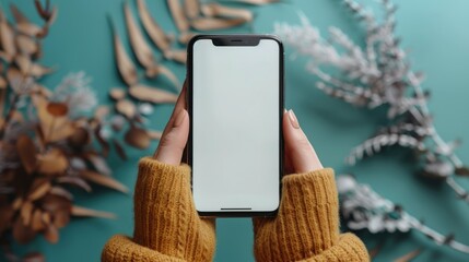 Wall Mural - Woman's hand is holding a smartphone with a white screen