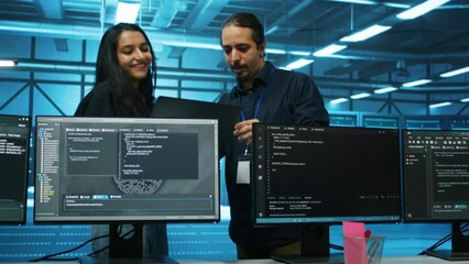 Engineers working in high tech server hub capable of processing and storing vast amounts of data. Specialists talking and troubleshooting server rows controlling network resources