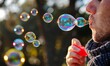 © wpw - A Person Blowing Soap Bubbles with Floating Bubbles Capturing