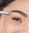 © peopleimages.com - Beauty, woman and tweezers for eyebrow with grooming, self care or hair removal routine. Confident, cosmetic and closeup of female person with epilation tool for natural face plucking treatment.