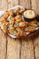 Sticker - Chicken Parmesan Wings are oven-baked or air-fried and then coated in a buttery garlic parmesan sauce closeup on the plate on the table. Vertical