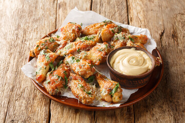 Wall Mural - Parsley Garlic Parmesan chicken wings served with dipping sauce close-up in a plate on the table. Horizontal