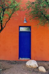 Wall Mural - Historic orange spanish mission styled home with blue door in Barrio Viejo , Tuscon, Arizona, United States of America.