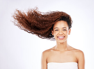 Poster - Portrait, studio and woman for haircare and beauty, shampoo and treatment on white background. Smile, face and conditioner for curly hair hydration, grooming and hairstyle with wind for female person