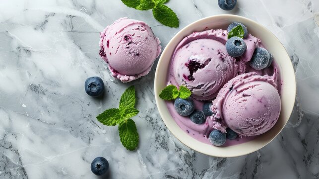 Refreshing black berry ice cream in a cup with berries and mint leaves on a light concrete background ,Scoops of berry ice cream and fresh blueberries ,Copy space, Happy National Ice Cream Day
