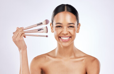 Poster - Studio portrait, cosmetics and happy woman with brushes for foundation with skin transformation and makeup results. Girl, skincare and beauty tools for facial glow and wellness by white background