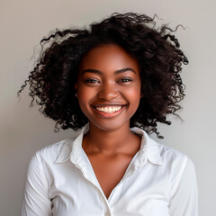 Wall Mural - A woman with curly hair is smiling and wearing a white shirt