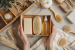 © Daniel - Beauty subscription Box preparation. Female hands holding gift box with natural skincare products, body brush, shampoo, soap, moisturizer.