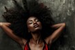 © anatolir - A woman with radiant skin and voluminous afro hair enjoys a peaceful moment