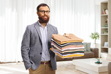 Poster - Man with a pile of folded clothes at home