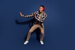 © deagreez - Full length photo of handsome good mood guy wear checkered shirt headphones dancing emtpy space isolated blue color background