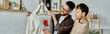 © Bliss - Two men, a gay couple, stand together in a designer workshop, collaborating on trendy attire creation.