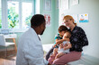© Marko Geber - Mother with two children visiting doctor in clinic