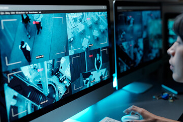 Computer monitors with cctv video on screens standing on workplace of security guard observing situations on every floor of modern hotel