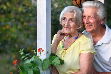 Wall Mural - Portrait of beautiful senior couple by lilacs in the park