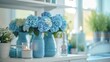 © Cheetose - Blue and white flowers in a blue vase sit on a white table against a bright window.