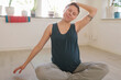 © Johnér - Smiling pregnant woman practicing yoga at home