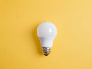 White light bulb on isolated yellow background with copy space