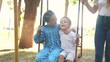 © maxximmm - two children on a swing. concept of a happy childhood and loving family. girl and boy in beautiful clothes swings on a swing on the lifestyle playground, they are being filmed by their parents